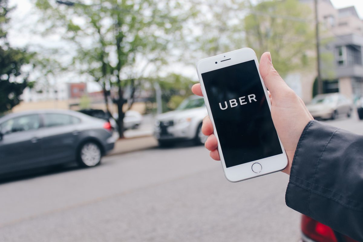 Hand holding phone with Uber on screen