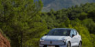 A car driving on the road with trees in the background